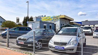 Ein Autohaus mit Autoankauf. Auf dem Hof stehen viele Gebrauchtwagen.